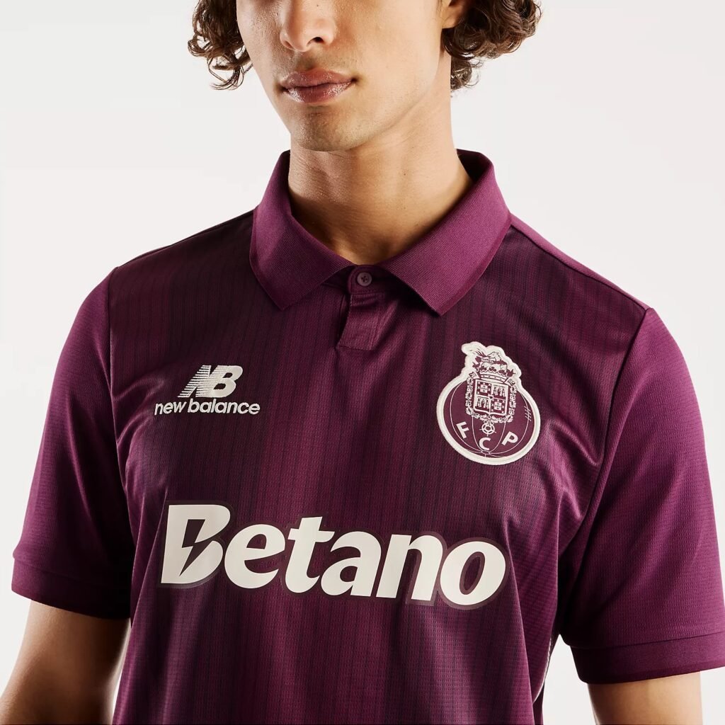 Detail of the one-button ruby polo collar and tonal stripe texture on the FC Porto 2026/27 away shirt.